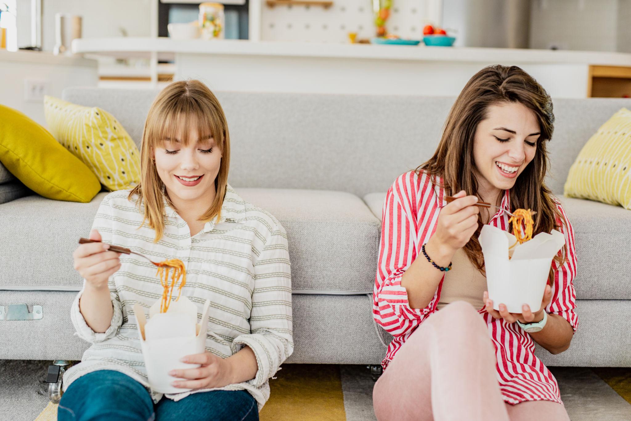 Friends enjoying takeout food together at home