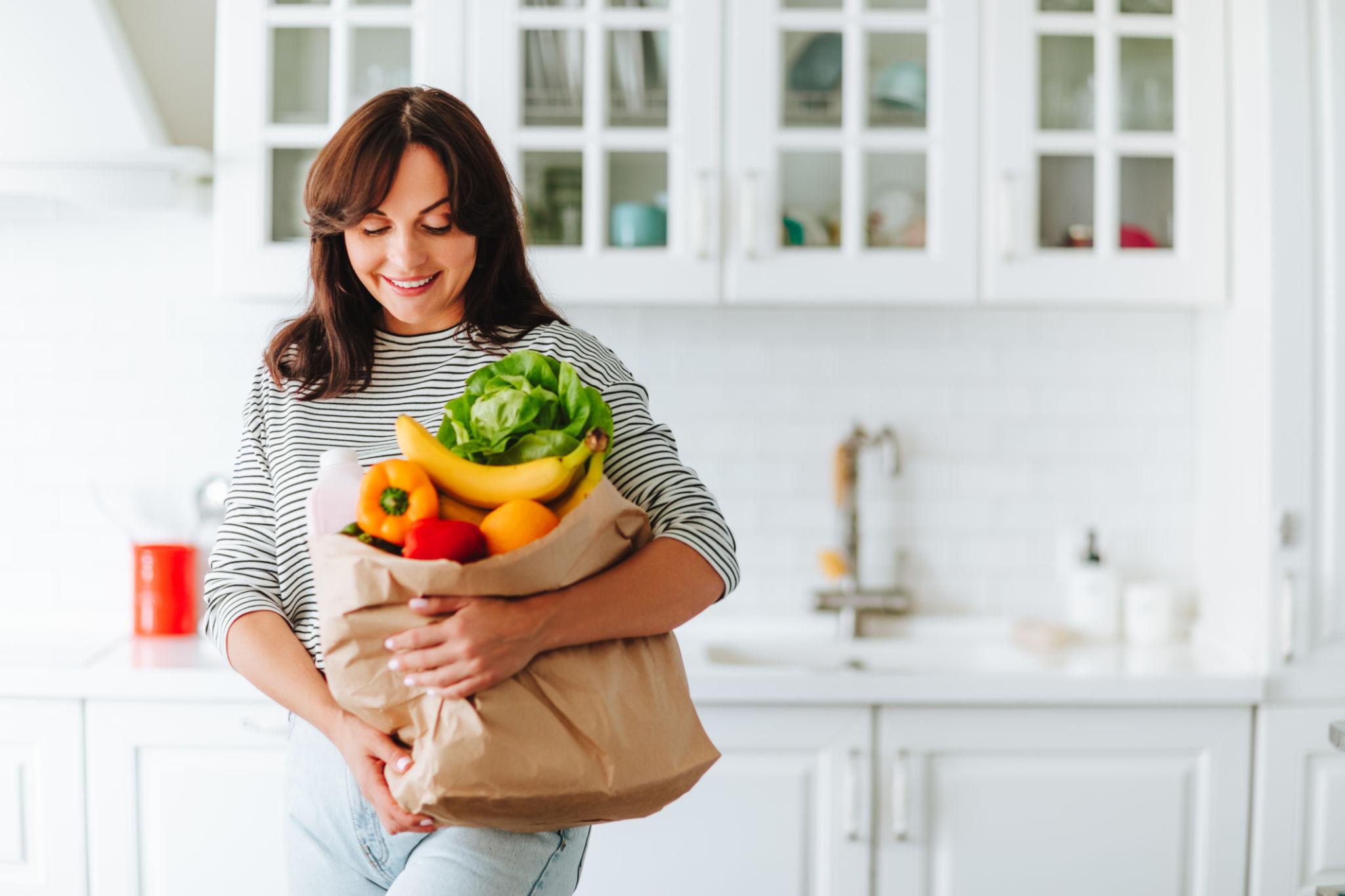 Food seller holding a bag of fresh ingredients in a bright kitchen