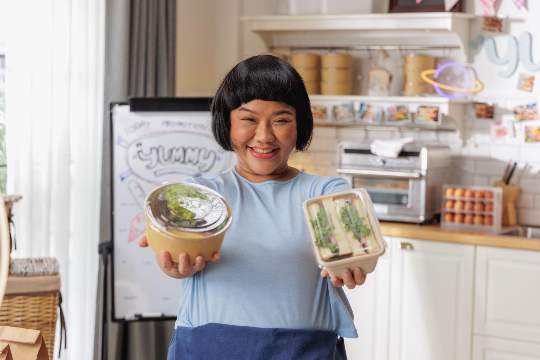 Food seller presenting packaged meals ready for pickup